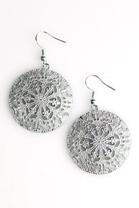 Brushed in a distressed gray finish, an ornate circular frame swings from the ear in a whimsical fashion. Earring attaches to a standard fishhook fitting.  Sold as one pair of earrings.