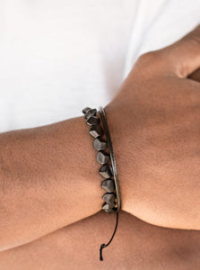 A strand of faceted black beads and a strand of shiny leather cording wrap around the wrist, creating dainty layers. Features an adjustable sliding knot closure.  Sold as one individual bracelet.