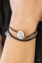 Load image into Gallery viewer, Mismatched strands of shiny cording and leather layer across the wrist. Featuring a strand of translucent blue beading, a shimmery silver tree charm is knotted across the wrist, creating a whimsical centerpiece. Features an adjustable sliding knot closure.  Sold as one individual bracelet.  Always nickel and lead free.