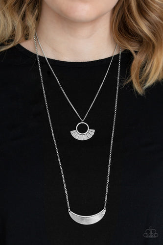 Radiating with linear patterns, a flared silver frame swings above a silver half-moon frame, creating tribal inspired layers below the collar. Features an adjustable clasp closure.  Sold as one individual necklace. Includes one pair of matching earrings.  Always nickel and lead free.