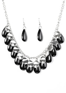 Polished black teardrops drip from the bottom of a shimmery silver chain, creating a colorful fringe below the collar. Featuring a delicately hammered surface, dainty silver teardrops are sprinkled along the chain for a splash of eye-catching shimmer. Features an adjustable clasp closure. Sold as one individual necklace. Includes one pair of matching earrings.