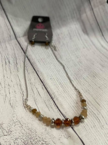 Varying in opacity, an enchanting collection of iridescent and crystal-like beads are threaded along an invisible wire that is attached to a gold chain below the collar. Mismatched gold beads and ornate gold accents are sprinkled between the glittery compilation, adding a whimsy sheen to the colorful statement piece. Features an adjustable clasp closure.  Sold as one individual necklace. Includes one pair of matching earrings.  Always nickel and lead free.   Fashion Fix Exclusive August 2021