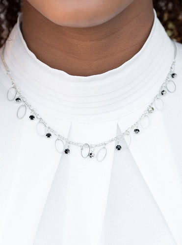 Glittery black rhinestones and dainty silver frames swing from a silver chain, creating a twinkling fringe below the collar. Features an adjustable clasp closure.  Sold as one individual necklace. Includes one pair of matching earrings.  