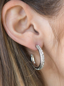 Encrusted in dazzling white rhinestones, a studded silver hoop swings from the ear for a glamorous look. Earring attaches to a standard post fitting. Hoop measures 1" in diameter.  Sold as one pair of hoop earrings.  