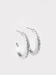 Encrusted in dazzling white rhinestones, a studded silver hoop swings from the ear for a glamorous look. 