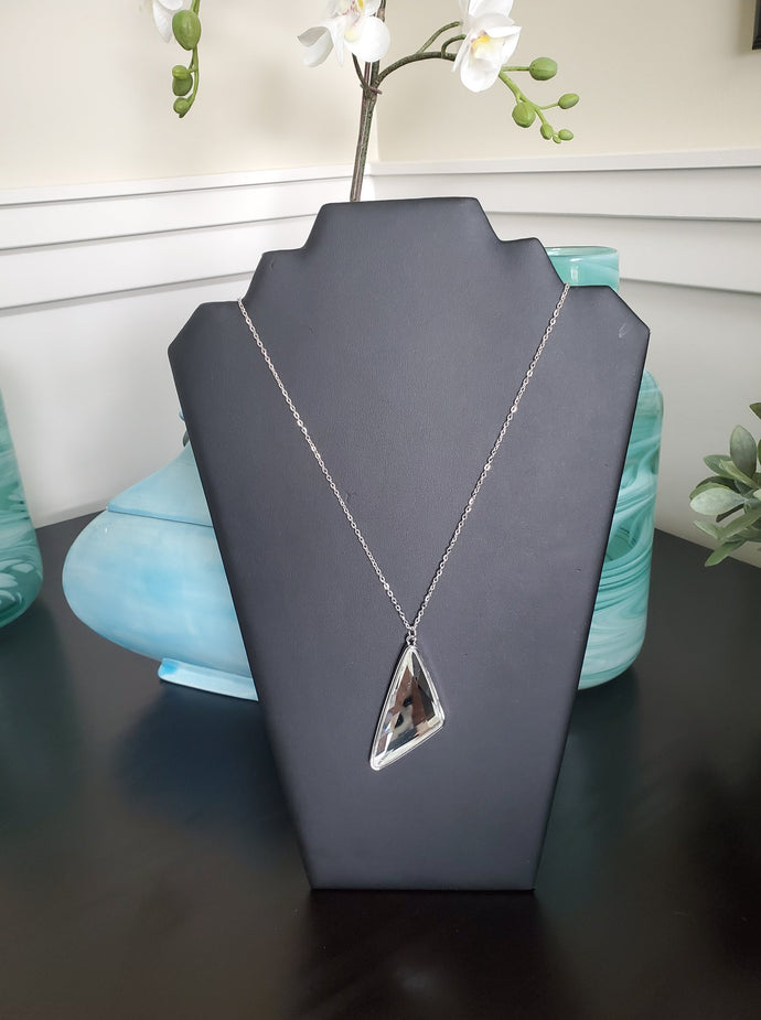 Cut into a striking triangular shape, a faceted white gem swings from the bottom of a lengthened silver chain for an edgy-glamorous fashion. Features an adjustable clasp closure.  Sold as one individual necklace. Includes one pair of matching earrings.  Always nickel and lead free.  August 2020 Fashion Fix Exclusive