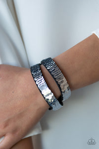 Row after row of shimmery sequins are stitched across the front of a lengthened black suede band. The elongated band allows for a trendy double wrap design. Bracelet features reversible sequins that change from silver to blue. Features an adjustable snap closure.  Sold as one individual bracelet.  Always nickel and lead free.
