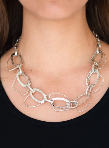 Embossed in glistening patterns, a collection of textured silver hoops connect with asymmetrical silver frames below the collar for an edgy industrial look. Features an adjustable clasp closure.  Sold as one individual necklace. Includes one pair of matching earrings.  