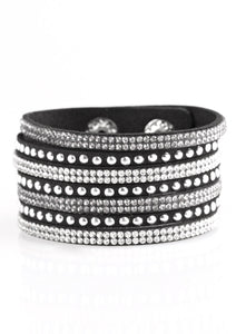 Shiny gold studs and rows of glittery white rhinestones are encrusted along strips of black suede, creating sassy shimmer around the wrist. Features an adjustable snap closure.  Sold as one individual bracelet.
