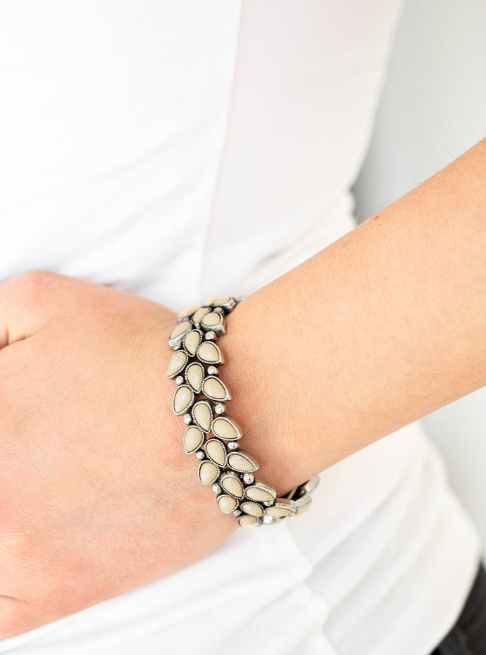 Faceted brown teardrop beads and shimmery silver studs coalesce into ornate frames. The whimsical frames are threaded along stretchy bands around the wrist for a seasonal look.  Sold as one individual bracelet.