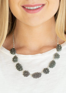 Encrusted in glittery hematite rhinestones, ornate filigree filled silver frames link below the collar for a vintage inspired style. Features an adjustable clasp closure.  Sold as one individual necklace. Includes one pair of matching earrings. 