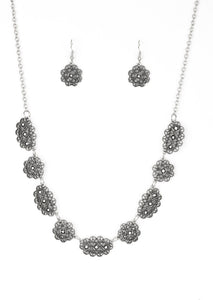 Encrusted in glittery hematite rhinestones, ornate filigree filled silver frames link below the collar for a vintage inspired style. Features an adjustable clasp closure.  Sold as one individual necklace. Includes one pair of matching earrings. 