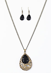 Featuring a regal teardrop shape, a faceted black bead is pressed into a larger brass teardrop, creating a whimsical pendant. Brushed in an antiqued shimmer, airy filigree climbs the bold pendant for a vintage inspired look. Features an adjustable clasp closure.  Sold as one individual necklace. Includes one pair of matching earrings.