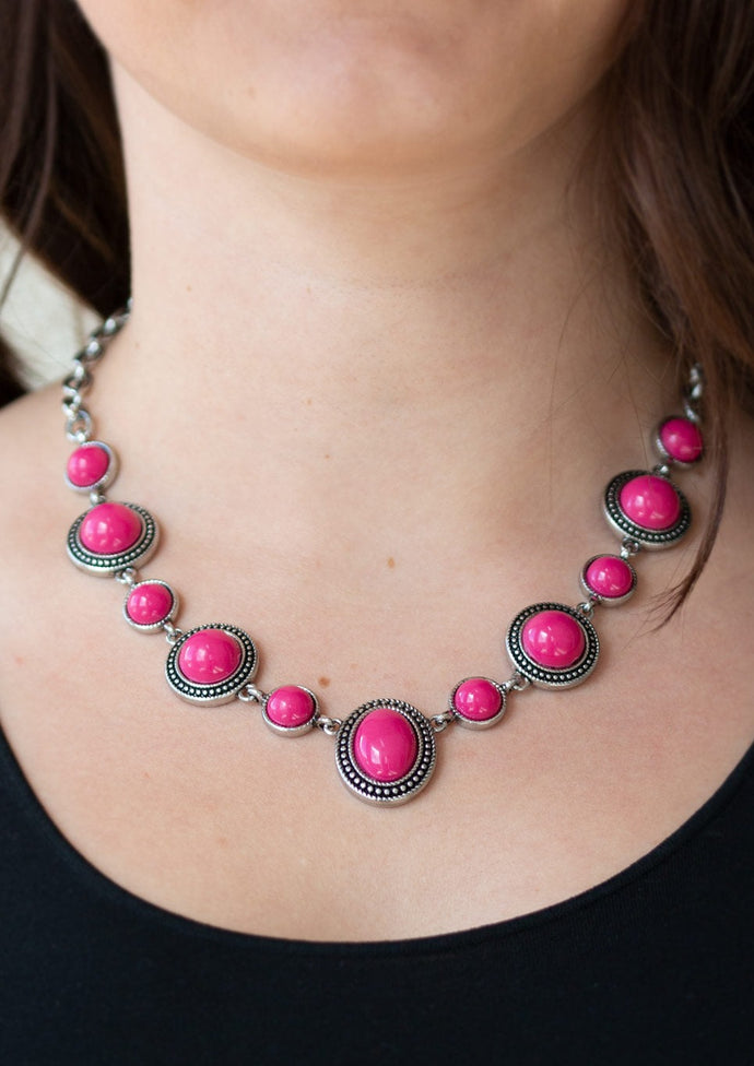 Featuring smooth and studded silver frames, vivacious pink beads link below the collar in a seasonal fashion. Features an adjustable clasp closure.  Sold as one individual necklace. Includes one pair of matching earrings.   