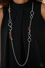 Load image into Gallery viewer, Delicately hammered in glistening textures, shimmery silver rings link asymmetrically along a silver chain. Featuring smooth and faceted surfaces, brown beads trickle along the chain for a colorful finish. Features an adjustable clasp closure.  Sold as one individual necklace. Includes one pair of matching earrings.  Always nickel and lead free.