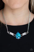 Load image into Gallery viewer, Cut into an alluring teardrop, an oversized blue rhinestone gem attaches to bold silver frames radiating with glassy white rhinestones. The dramatic pendant attaches to doubled silver chains, swinging horizontally below the collar in a glamorous fashion. Features an adjustable clasp closure.  Sold as one individual necklace. Includes one pair of matching earrings.   Always nickel and lead free.