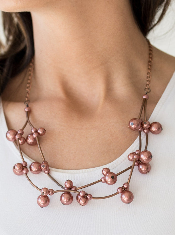 Cylindrical copper beads and clusters of pearly copper beads are threaded along invisible wires, creating bubbly layers below the collar for a refined look. Features an adjustable clasp closure.  Sold as one individual necklace. Includes one pair of matching earrings.
