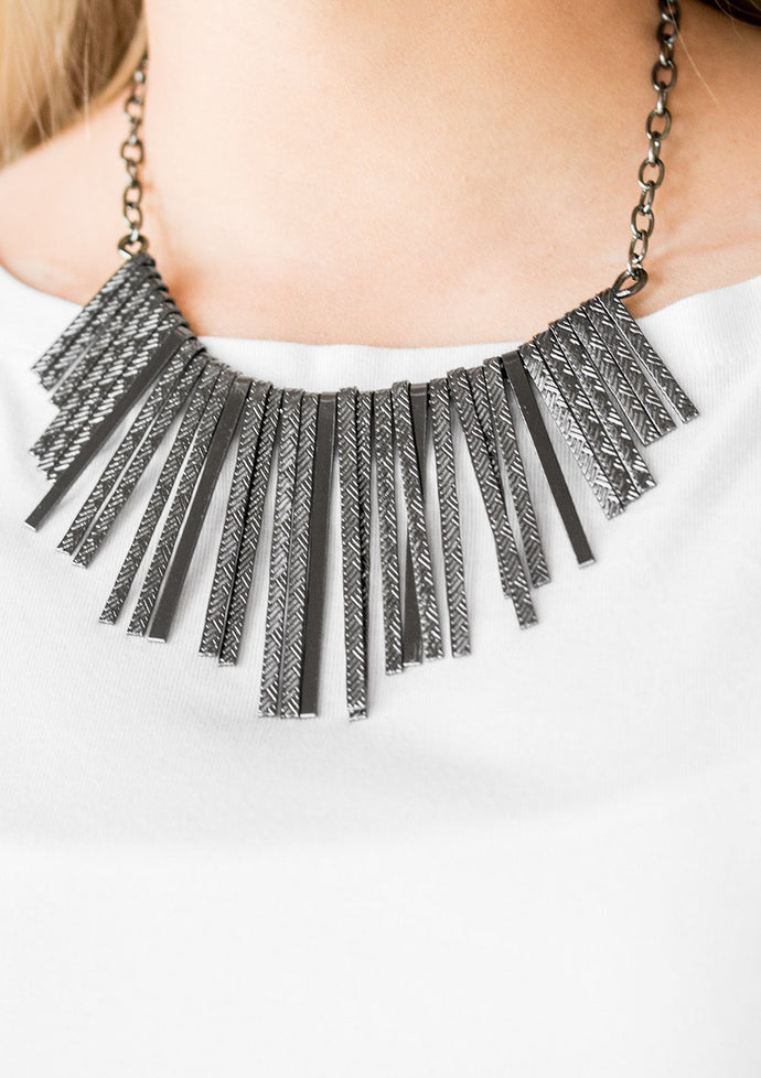 Embossed in edgy linear patterns, flat gunmetal rods alternate with plain gunmetal rods below the collar, creating a fiercely tapered fringe. Features an adjustable clasp closure.  Sold as one individual necklace. Includes one pair of matching earrings.