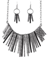 Load image into Gallery viewer, Embossed in edgy linear patterns, flat gunmetal rods alternate with plain gunmetal rods below the collar, creating a fiercely tapered fringe. Features an adjustable clasp closure.  Sold as one individual necklace. Includes one pair of matching earrings.