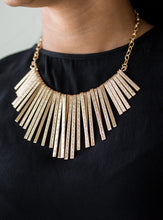 Load image into Gallery viewer, Embossed in edgy linear patterns, flat gold rods alternate with plain gold rods below the collar, creating a fiercely tapered fringe. Features an adjustable clasp closure.  Sold as one individual necklace. Includes one pair of matching earrings. 