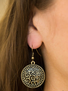 Brushed in an antiqued shimmer, a studded brass disc is embossed in vine-like filigree for a whimsical look. Earring attaches to a standard fishhook fitting.  Sold as one pair of earrings.
