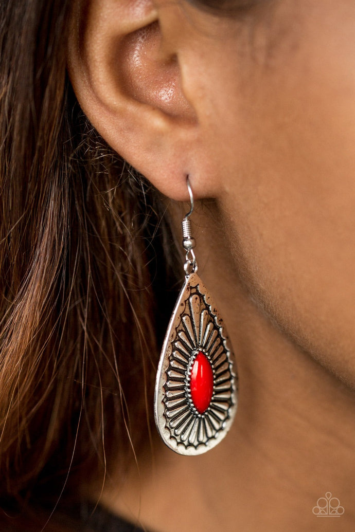 A shiny red bead is pressed into the center of a textured silver teardrop, creating a tribal inspired lure. Earring attaches to a standard fishhook fitting.  Sold as one pair of earrings.