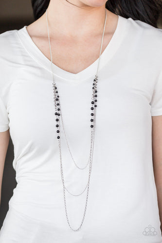Dainty black beads are sporadically sprinkled along trestles of shimmering silver chain. Infused with an elegant elongated silver chain, the layered palette dramatically falls down the chest in a refined fashion. Features an adjustable clasp closure.