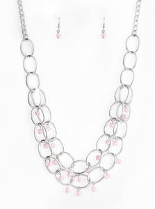 Pink crystal-like beads swing from two layers of oversized silver links below the collar for a refined look. Features an adjustable clasp closure.  Sold as one individual necklace. Includes one pair of matching earrings.