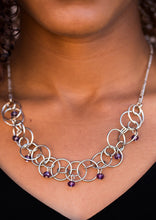 Load image into Gallery viewer, Shimmery silver hoops link below the collar, creating a bold industrial chain. Purple crystal-like beads cascade from the airy hoops for a sparkling finish. Features an adjustable clasp closure.  Sold as one individual necklace. Includes one pair of matching earrings.  