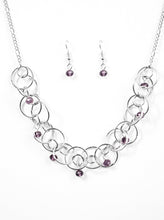 Load image into Gallery viewer, Shimmery silver hoops link below the collar, creating a bold industrial chain. Purple crystal-like beads cascade from the airy hoops for a sparkling finish. Features an adjustable clasp closure.  Sold as one individual necklace. Includes one pair of matching earrings.