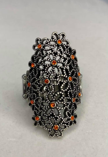 Dotted with dainty orange rhinestone centers, a bouquet of silver flowers blooms across the finger for a seasonally whimsical look. Features a stretchy band for a flexible fit.  Sold as one individual ring.  Always nickel and lead free.  Fashion Fix February 2021 Exclusive