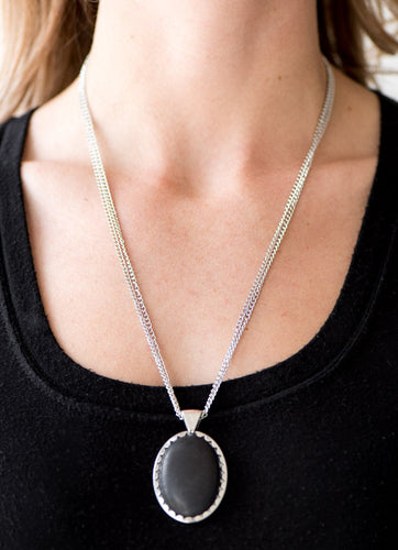 A smooth black stone is pressed into the center of an ornate silver frame, creating a dramatic pendant below the collar. Features an adjustable clasp closure.  Sold as one individual necklace. Includes one pair of matching earrings.  Always nickel and lead free.