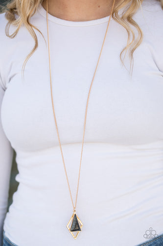 Chiseled into an alluring triangle, a black stone is pressed into a sleek gold frame. The neutral stone joins a diamond-shape frame at the bottom of the elongated gold chain for a seasonal look. Features an adjustable clasp closure.  Sold as one individual necklace. Includes one pair of matching earrings.